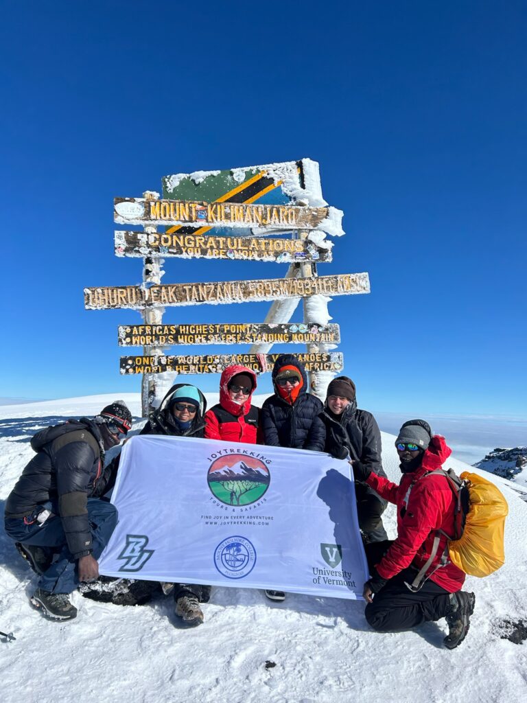 Climbers celebrating at Uhuru Peak on Mount Kilimanjaro after completing a successful Kilimanjaro adventure tour