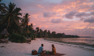 Couple enjoying a private beach picnic in Zanzibar at dusk