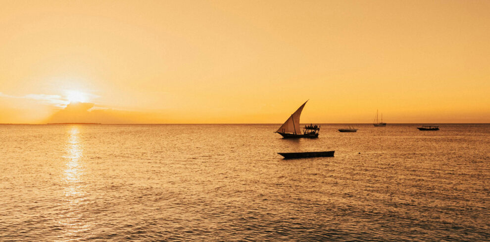 Traditional Dhow sailing boat at sunset in Zanzibar