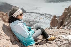Climber resting on Mount Kilimanjaro to cope with altitude sickness and acclimatization – illustrating how hard is to climb Mount Kilimanjaro

