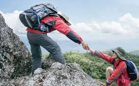 Climber being assisted by a fellow climber on Mount Kilimanjaro, demonstrating mental and psychological challenges – illustrating how hard is to climb Mount Kilimanjaro
