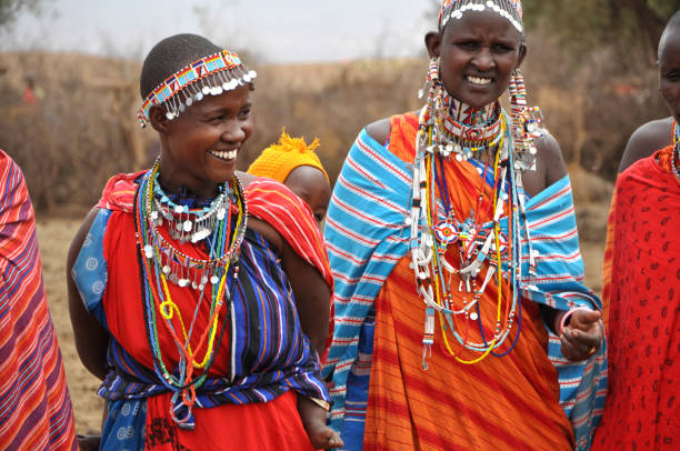 Maasai women wearing traditional bead jewelry welcoming visitors during Maasai Village Tours in Tanzania
