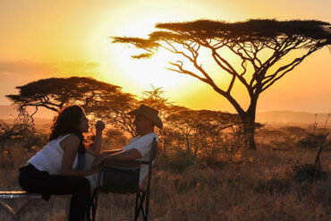 Bridal couple enjoying a sunset during Romantic Safari Adventures in Tanzania
