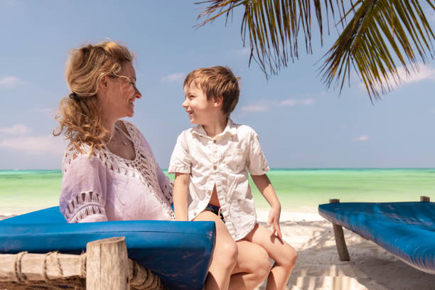 Happy mother and child relaxing on a deck chair at Zanzibar Island, a perfect beach escape for a Tanzania Family Vacation