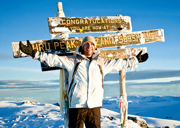 How Difficult Is It to Climb Mount Kilimanjaro? Happy climber celebrating at Uhuru Peak summit