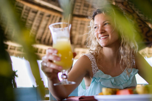 Traveler enjoying sugarcane juice with tangawizi as part of Unique Foods in Zanzibar experience