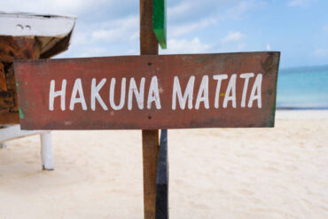 “Hakuna Matata” sign on sandy beach in Tanzania, illustrating basic Swahili words for travellers