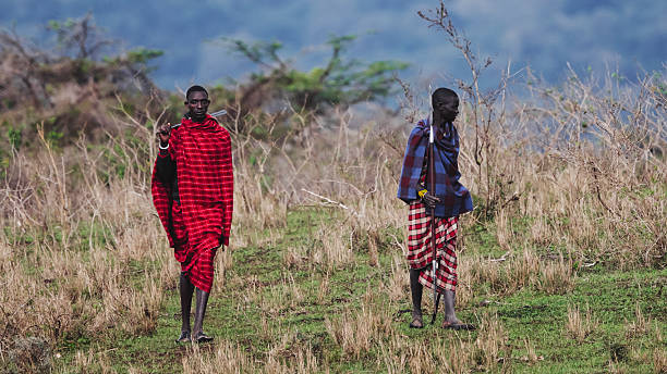 Two Maasai people in traditional attire near Ngorongoro Crater, Tanzania, showcasing local culture during a safari