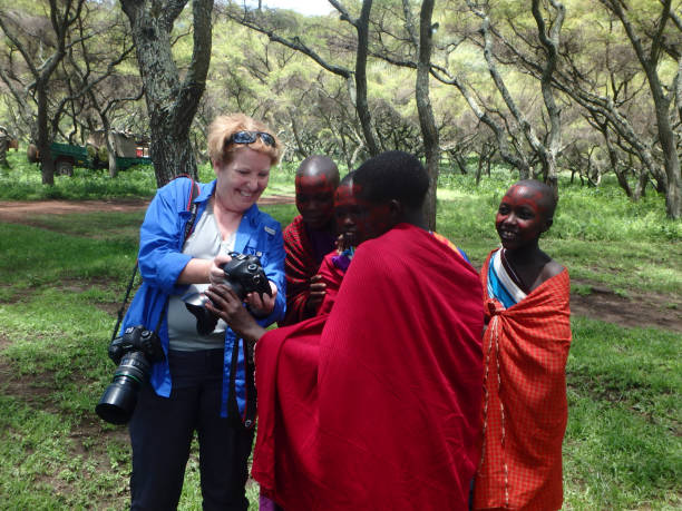 Tourist showing photos to Maasai girls during a cultural visit in Ngorongoro Conservation Area Tanzania