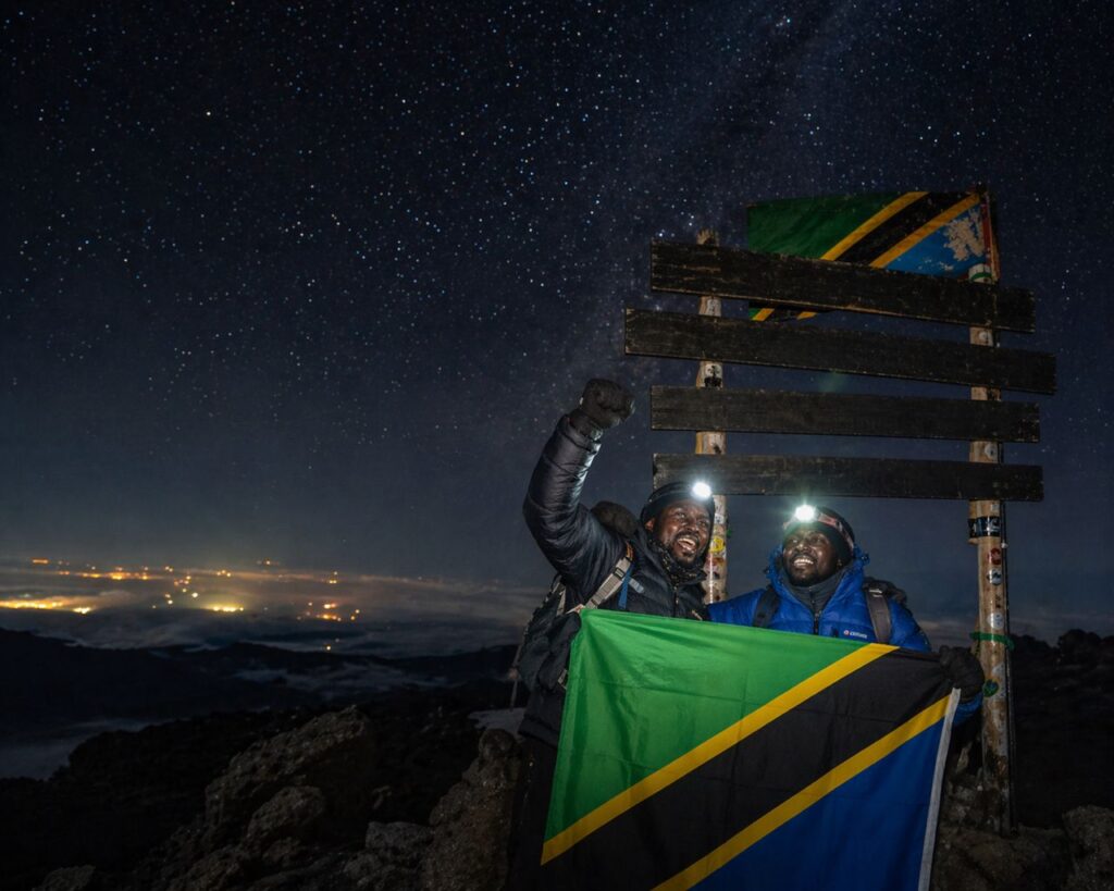 Climbers on summit night with headlamps under stars facing altitude sickness on Kilimanjaro