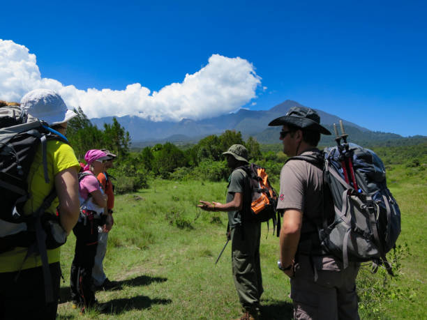 Mount Meru trekking guide packing list showing tourists preparing hiking gear, backpacks, boots, jackets, and equipment for Mount Meru trekking adventure in Tanzania