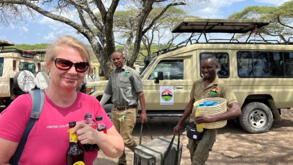 Female tourist with a Joytrekking guide and driver taking a lunch break during a private safari