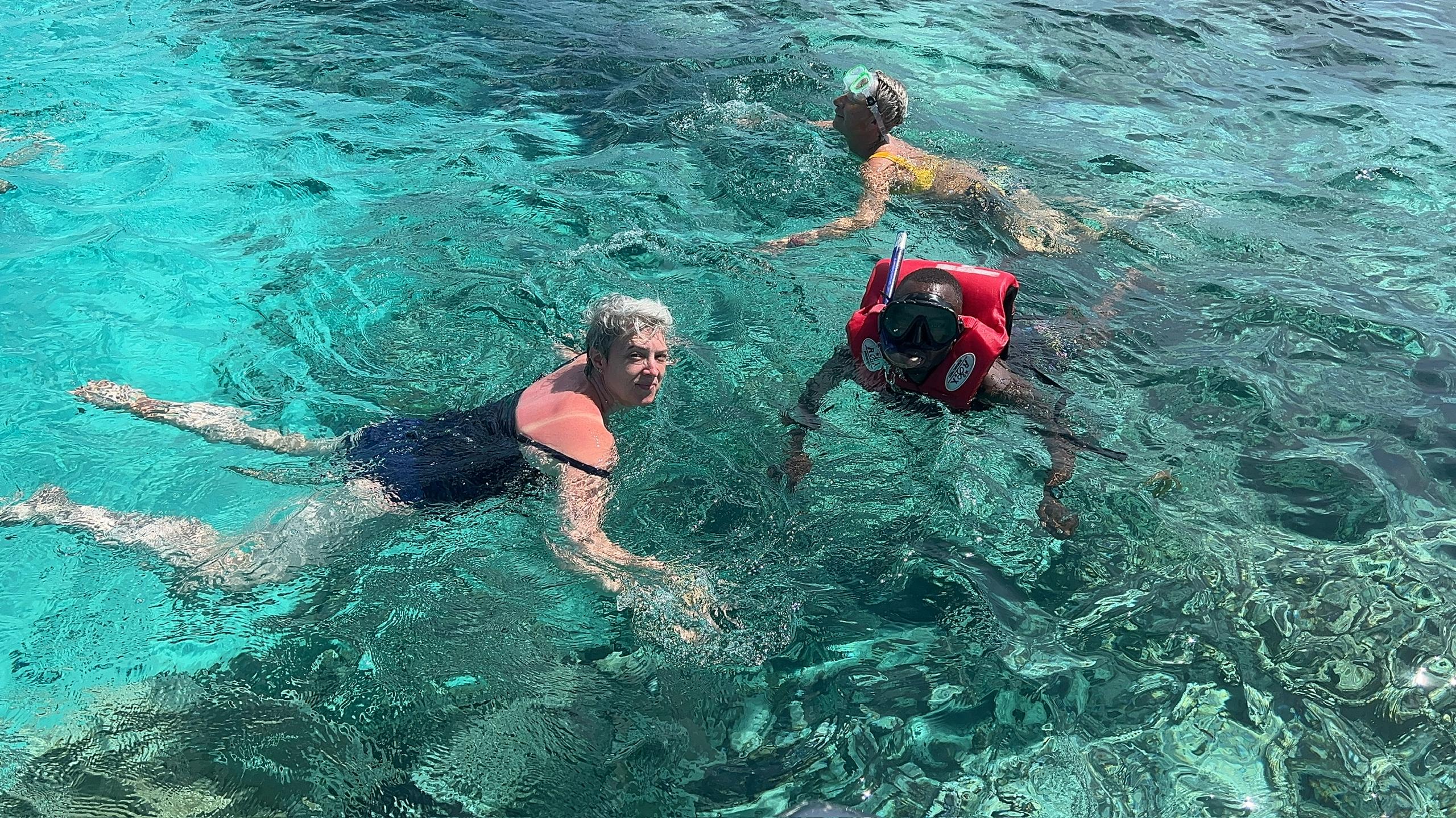 Scuba Diving in Tanzania January and Travellers with scuba mask and snorkel standing in crystal clear sea looking at a starfish