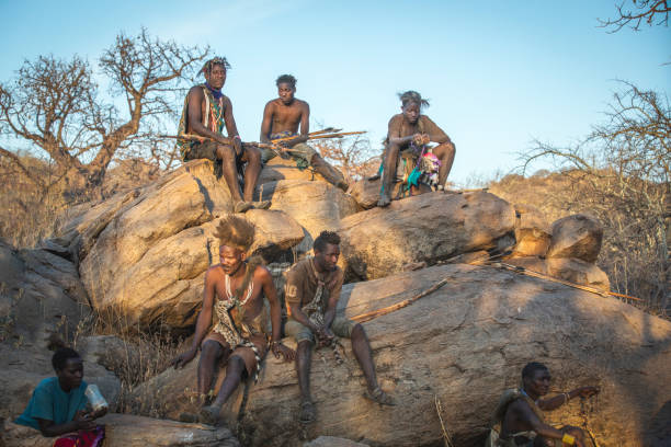 Lake Eyasi Cultural Experience – Hadzabe men resting on rocks after a hunting trip at sunset in Tanzania