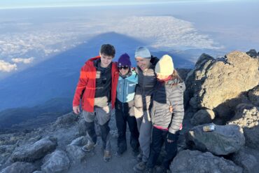 “Four international climbers trekking Mount Kilimanjaro routes in Tanzania during summit expedition”
