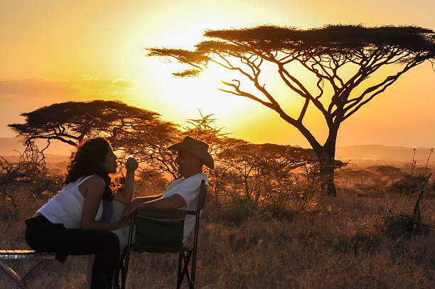 Bridal couple enjoying a romantic sunset in Serengeti at one of the best honeymoon destinations in Tanzania