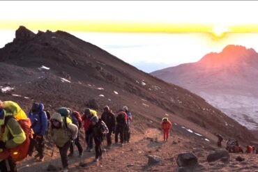 Climbers and guides at Stella Point 5720m experiencing altitude sickness on Kilimanjaro during summit attempt