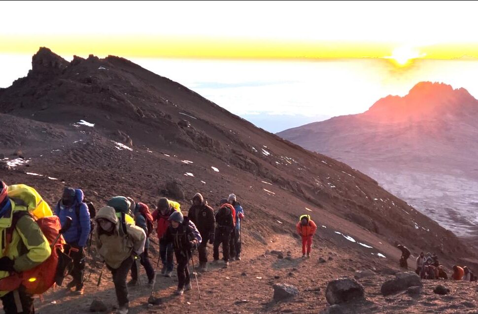 Climbers and guides at Stella Point 5720m experiencing altitude sickness on Kilimanjaro during summit attempt
