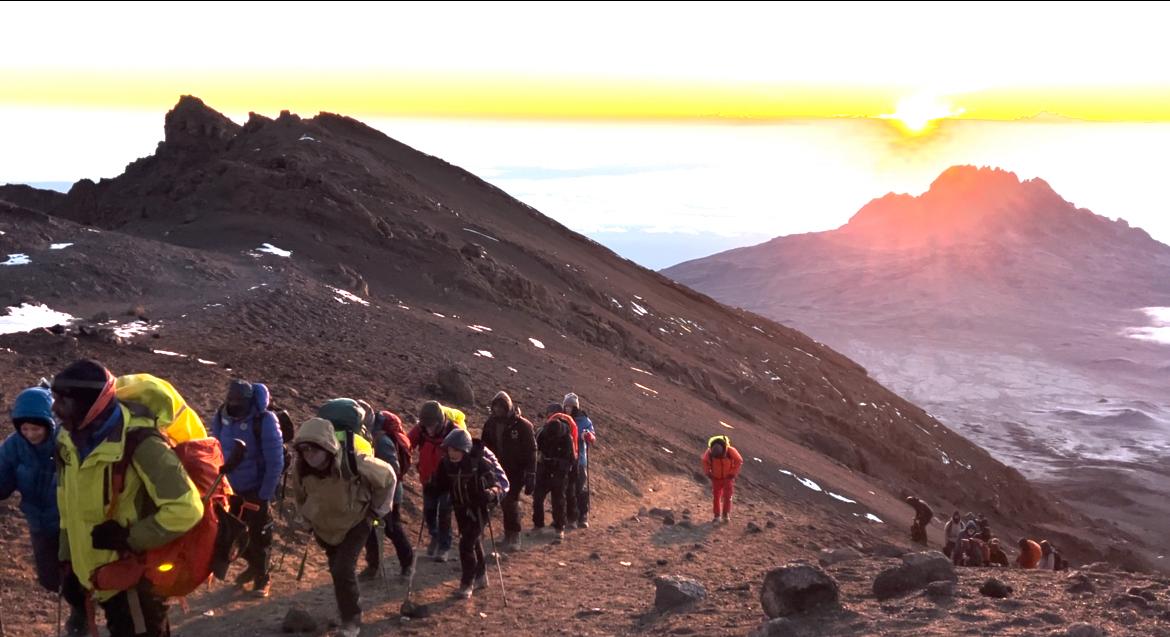 Climbers and guides at Stella Point 5720m experiencing altitude sickness on Kilimanjaro during summit attempt