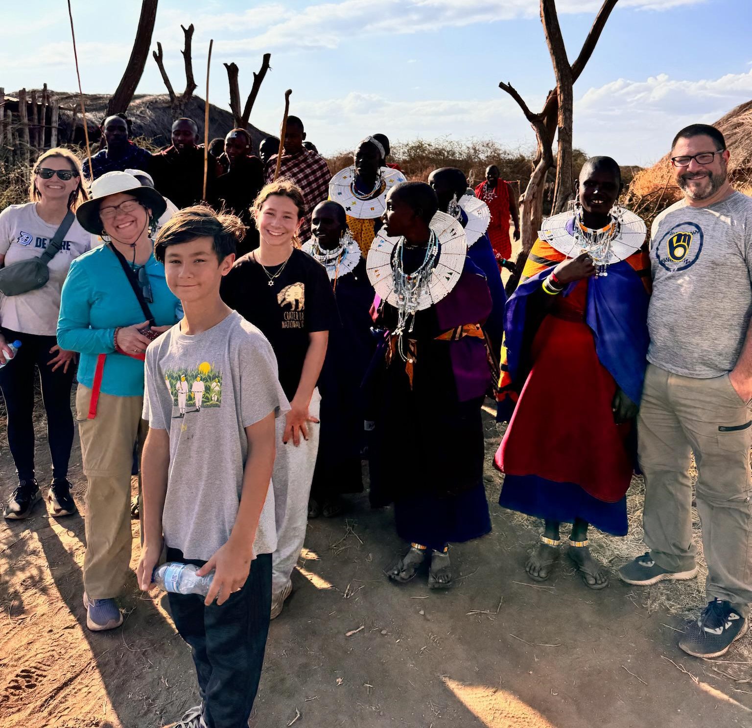 International travelers experiencing Maasai culture in a traditional village during a Tanzania Local Experience Guide tour