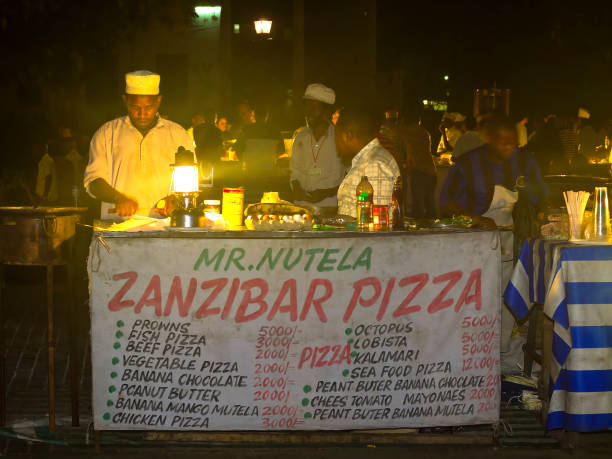 Tourists buying Zanzibar Traditional Foods at a night street food market in Stone Town, Zanzibar, Tanzania
