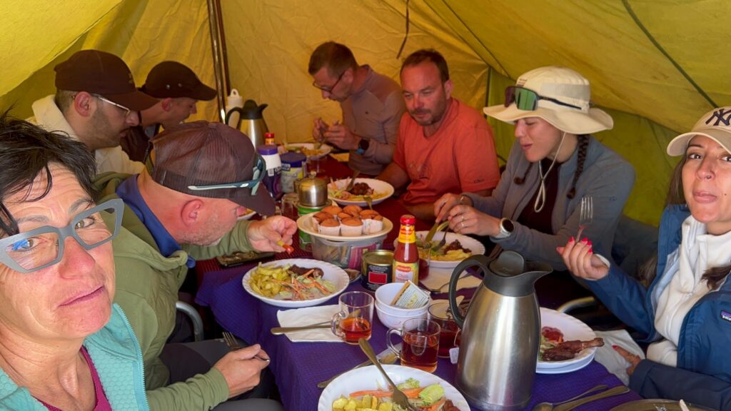 Group of international tourists enjoying a shared meal during safari with JoyTrekking Tours & Safaris, highlighting responsible tour company in Tanzania experiences
