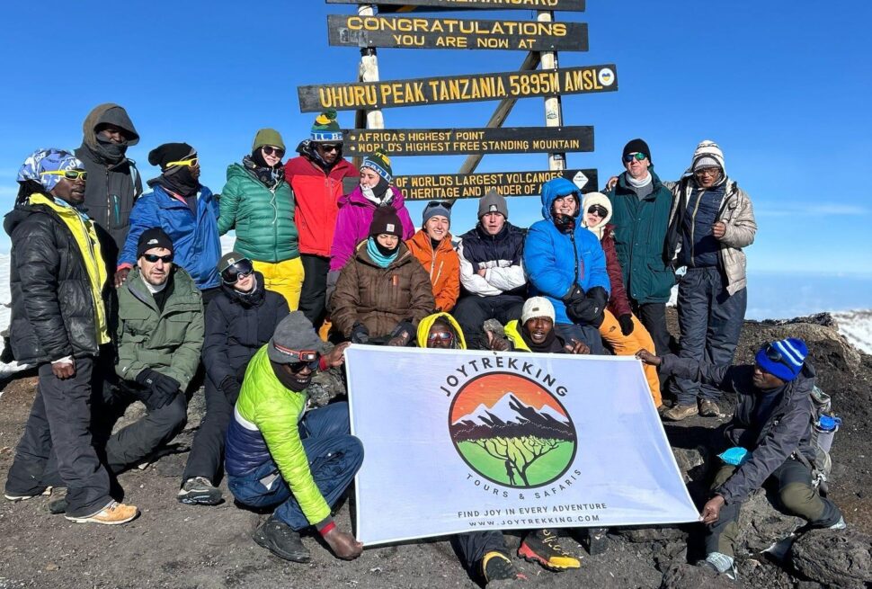 Climbers at Uhuru Peak after a successful Kilimanjaro climb with an experienced Kilimanjaro trekking company.