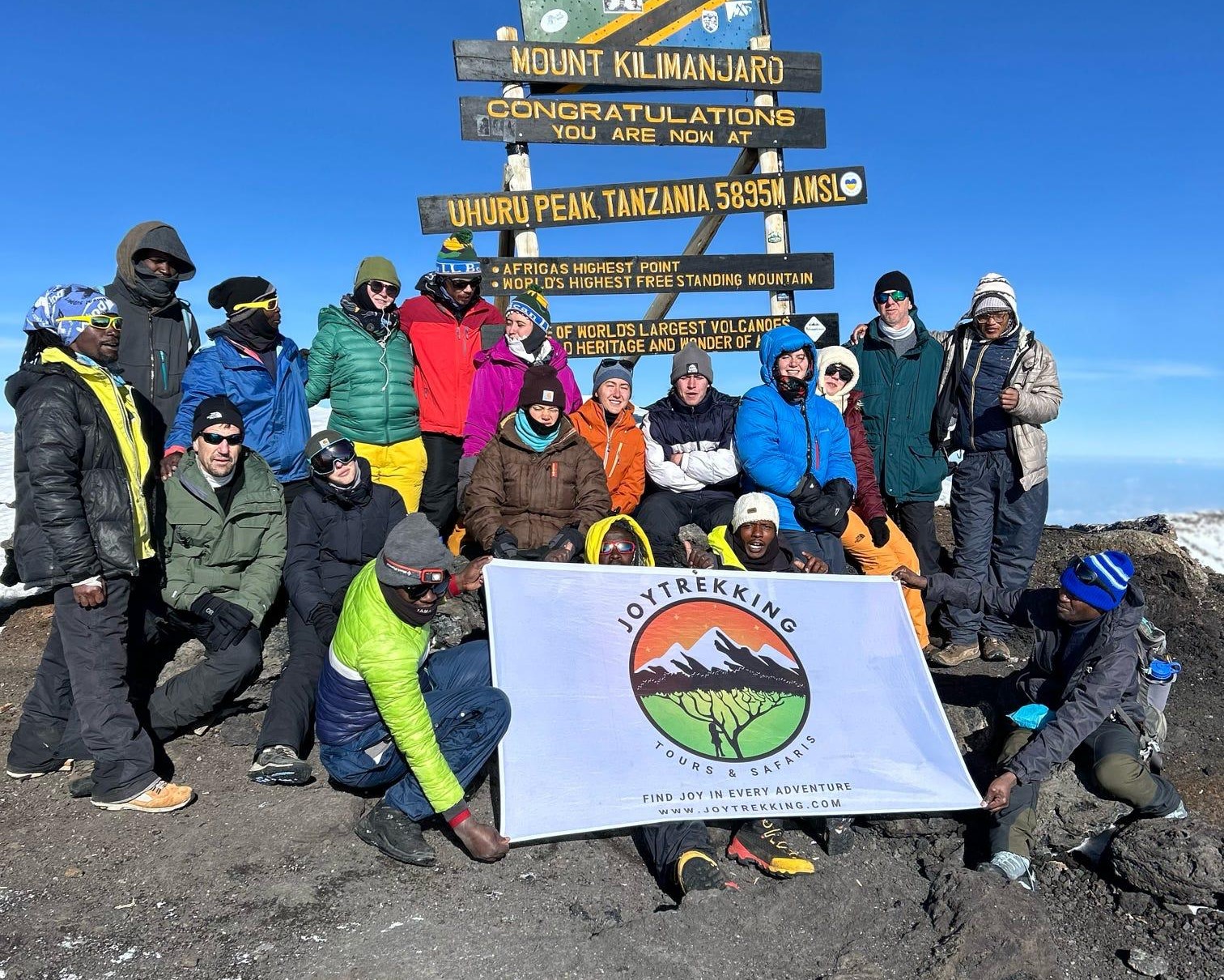 Climbers at Uhuru Peak after a successful Kilimanjaro climb with an experienced Kilimanjaro trekking company.