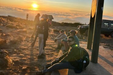 Cost of Climbing Mount Kilimanjaro – climbers at a mountain camp enjoying sunrise views during a Kilimanjaro trekking expedition in Tanzania