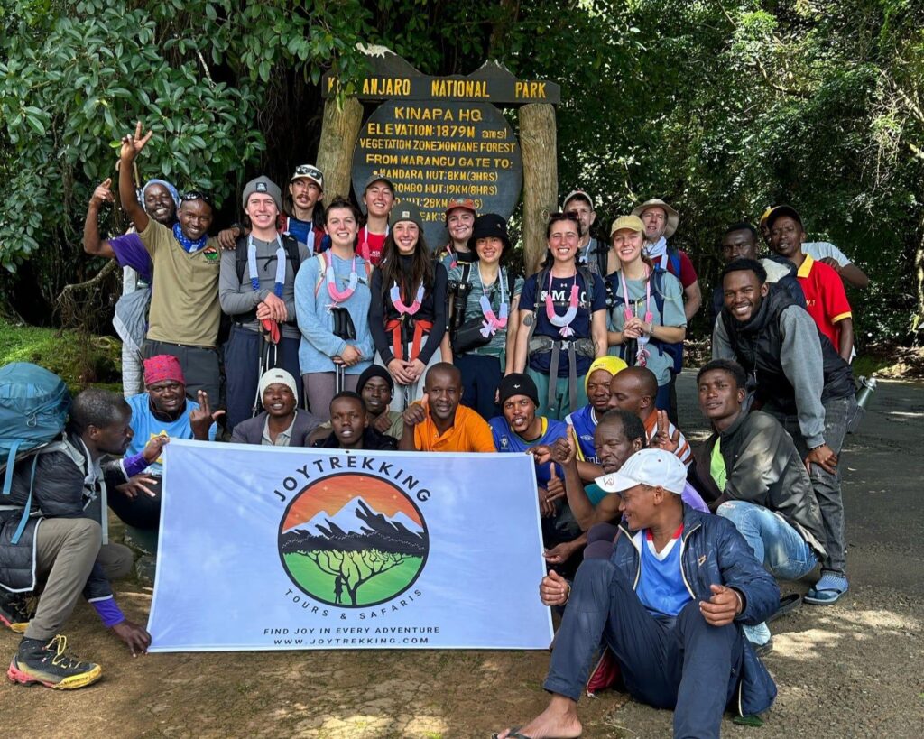 International climbers, JoyTrekking guide and mountain porters at Kilimanjaro National Park headquarters with JoyTrekking Tours & Safaris, a best local tour operator in Tanzania
