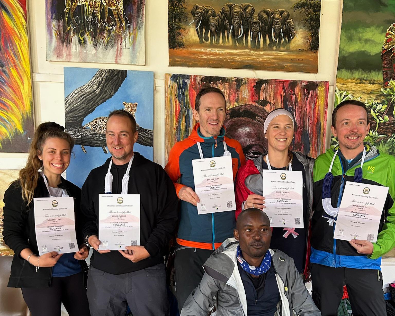 Best Tanzania travel experts Kilimanjaro summit success group of climbers celebrating after reaching Uhuru Peak with certificates