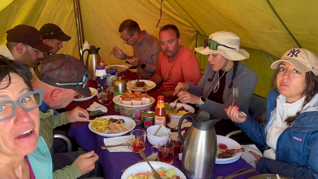 Luxury Kilimanjaro Climb experience with trekkers enjoying freshly prepared meals inside a mountain dining tent in Tanzania