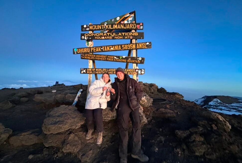 Kilimanjaro Climbing Fees guide showing a happy couple celebrating at Uhuru Peak summit in Tanzania