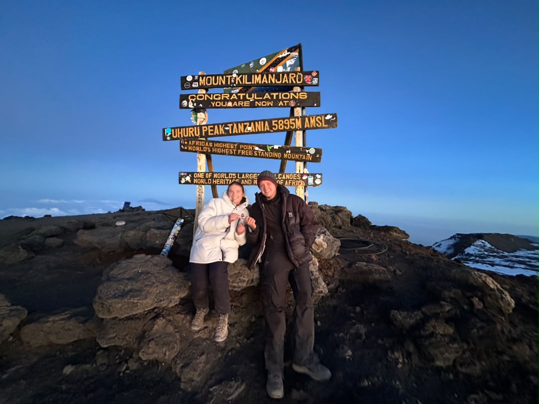 Kilimanjaro Climbing Fees guide showing a happy couple celebrating at Uhuru Peak summit in Tanzania
