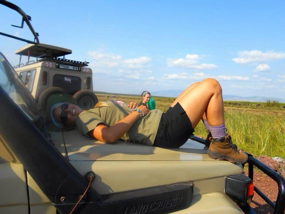 7 Day Tanzania Safari Cost experience with a female traveler relaxing on a safari Land Cruiser during Tarangire Serengeti and Ngorongoro safari