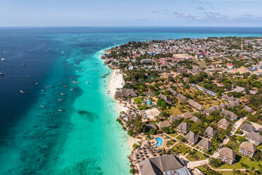 Cost of Visiting Zanzibar – aerial view of Nungwi Beach showcasing turquoise waters, white sandy beaches, luxury resorts, and the vibrant coastline in Zanzibar, Tanzania.