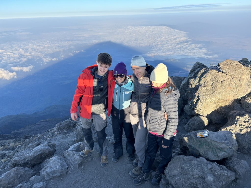 Best pre-climb activities in Arusha with hikers standing on Mount Meru during a Kilimanjaro acclimatization trek