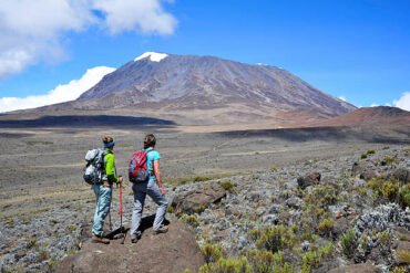 Two women overlooking Mount Kilimanjaro route on an 8 days trekking package in Tanzania