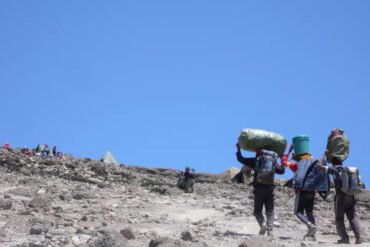 6-Day Umbwe Route Cost – porters carrying climbing equipment to Barafu Camp on Mount Kilimanjaro