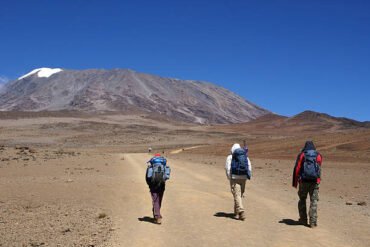 Three trekkers climbing Mount Kilimanjaro during a 7-day trek in Tanzania