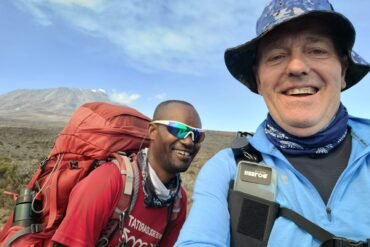 Traveller trekking Mount Kilimanjaro with a guide during an 8-day Kilimanjaro trek