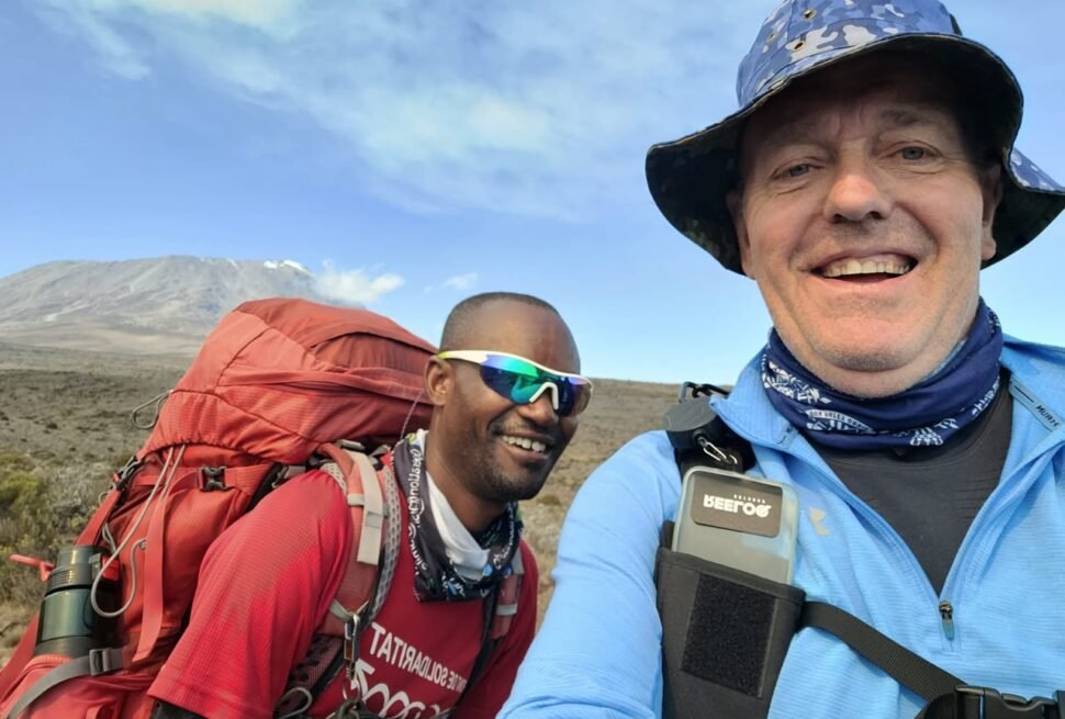 Traveller trekking Mount Kilimanjaro with a guide during an 8-day Kilimanjaro trek