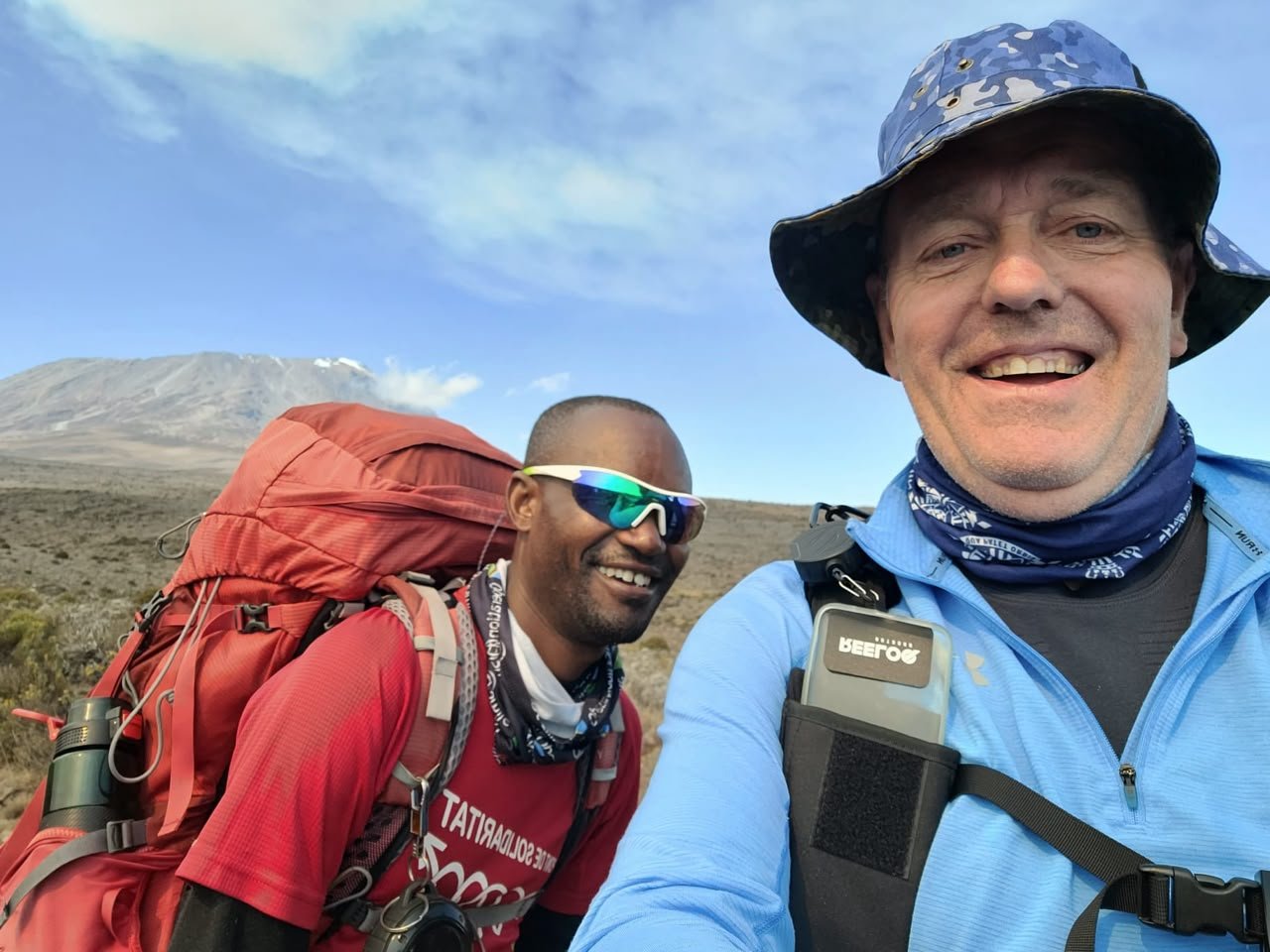 Traveller trekking Mount Kilimanjaro with a guide during an 8-day Kilimanjaro trek